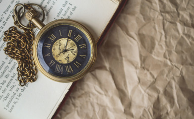 Pocket Watch with Old Books on Crumpled Paper in Vintage Tone