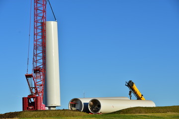 Installing base section of tower for wind turbine as part of wind farm generating clean power in ND.