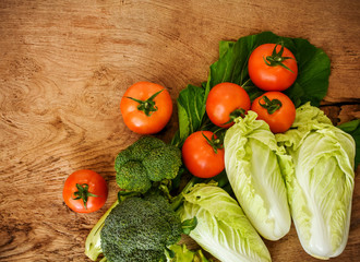Mixed organic vegetables for healthy eating.Tomatoes,Broccoli,Celery and Chinese cabbages on rustic wood background.