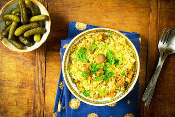 Asian rice with meat and vegetables on wooden table