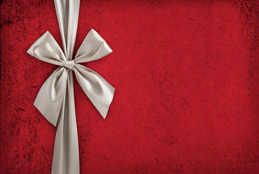 White ribbon bow over red paper, christmas backdrop, gift box background