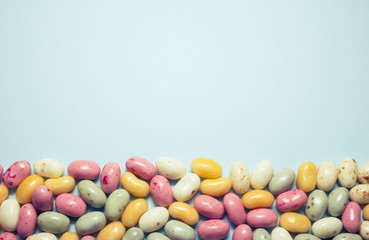Jelly Beans auf blauem Untergrund mit Textfreiraum.
