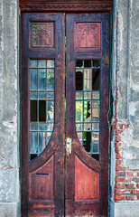 Vintage weathered wood door. Broken glass. Wall