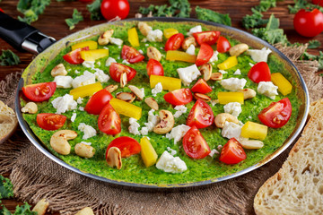 Vegetable Green Omelette with tomatoes, kale, greek cheese, olives, nuts, toast on wooden background. concept healthy food