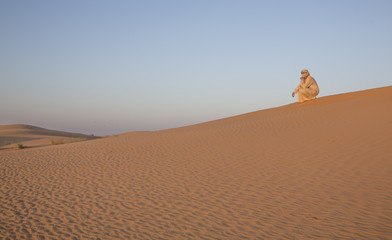 man in traditional outfit in a desert near Dubai