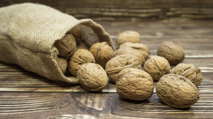 Walnut in a Bag on Wooden Background