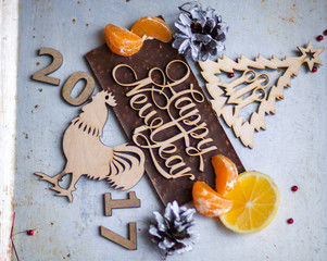 Wooden inscription Happy New Year and a rooster is on top of the