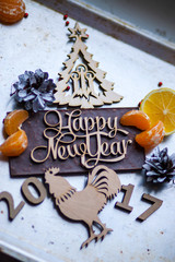 Wooden inscription Happy New Year and a rooster is on top of the