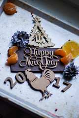 Wooden inscription Happy New Year and a rooster is on top of the