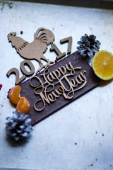 Wooden inscription Happy New Year and a rooster is on top of the