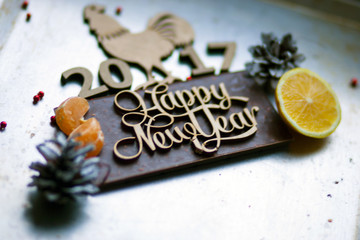 Wooden inscription Happy New Year and a rooster is on top of the