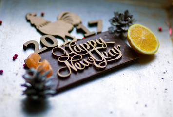 Wooden inscription Happy New Year and a rooster is on top of the