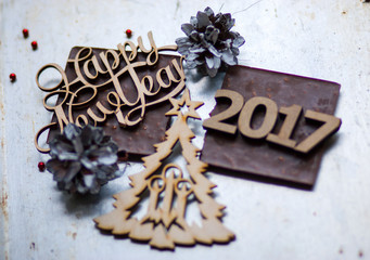 A wooden sign New Year, numbers 2017 and Christmas tree is on to