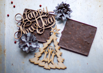 A wooden sign New Year and Christmas tree is on top of the choco