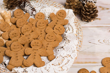 Many Christmas smiling  gingerbread men on white lace