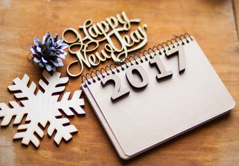 Wooden figures and notebook lying on a brown table