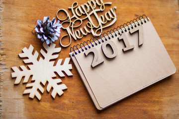 Wooden figures and notebook lying on a brown table