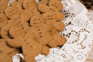 Many Christmas smiling  gingerbread men on white lace