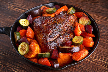 Oven baked Juicy pork loin with vegetables in griddle rustic pan