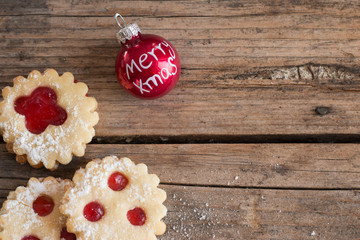 Weihnachtskekse und Weihnachtskugel auf rustikalem Holz