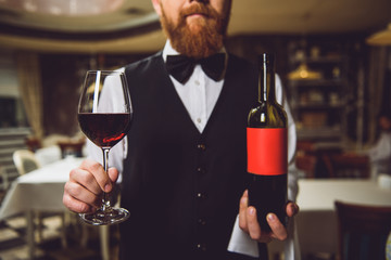 Man showing bottle and glass of red wine
