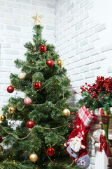 Christmas socks hanging on the mantelpiece and wait for Santa Claus. Decorated Christmas tree for Christmas and New Year.