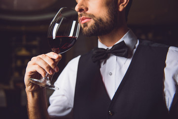 Concentrated sommelier inhaling race of wine - obrazy, fototapety, plakaty