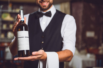 Smiling man holding bottle with alcohol