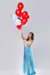 Woman wearing beautiful dress with a lot of colorful balloons