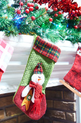 Unusual stockings for Santa Claus hanging on the fireplace and the mantel. Christmas stocking as snowman.