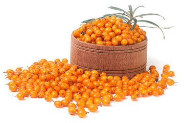 Sea-buckthorn berries in a wooden bowl with leaves isolated on white background