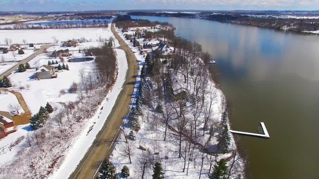 Aerial view of wealthy riverfront homes covered in fresh snow. This is the Fox River near De Pere Wisconsin.