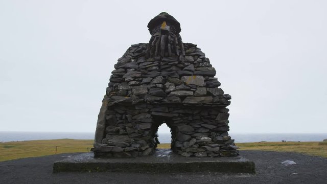 Iceland. Sculpture of Bardur on Snaefellsnes peninsula in West Iceland. Icelandic statue from Bardar Saga. Large stone sculpture of troll man at Arnarstapi. RED EPIC SLOW MOTION.