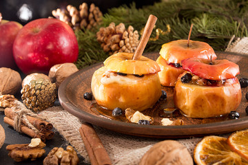 Baked apples on brown plate with holiday Christmas decoration