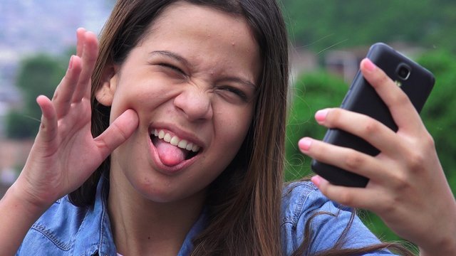Silly Goofy Girl Making Funny Faces And Taking Selfy