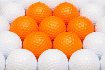 White and orange golf balls in the box