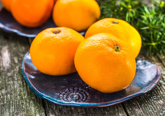Ripe Mandarin fruit peeled open and place on old rustic look tim