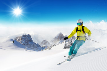 Skier on piste running downhill