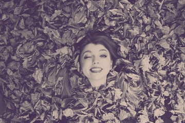 Young lady covered by leaves.