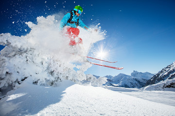 Freeride skier jumping from rock