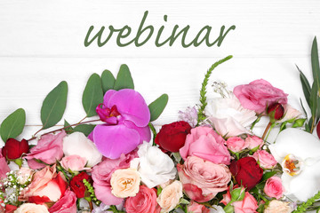 Obraz na płótnie Canvas Word WEBINAR and flowers on white wooden background. Florist and floral design tutorial concept.
