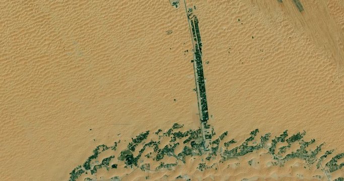 High-altitude overflight aerial of a highway out of the Liwa oasis, Abu Dhabi. Clip loops and is reversible. Elements of this image furnished by USGS/NASA Landsat 

