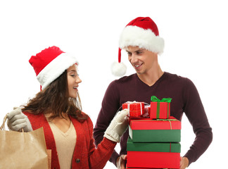 Young couple with Christmas purchases on white background