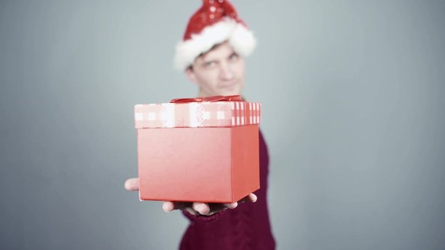 Young man gives a gift. Congratulate New Year, Merry Christmas, presents gifts