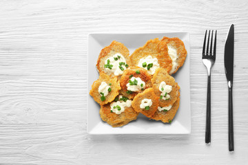 Plate with tasty potato pancakes for Hanukkah on wooden table