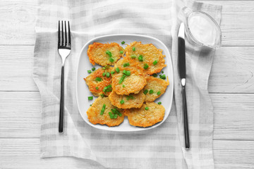 Plate with tasty potato pancakes for Hanukkah on wooden table