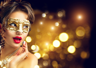 Beauty model woman wearing venetian masquerade carnival mask at party. Christmas and New Year...