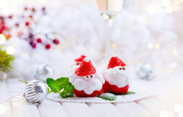 Fototapeta na wymiar Christmas strawberry Santa. Funny dessert stuffed with whipped cream. Xmas party food idea