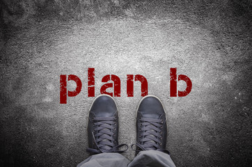 Plan B stencil print with sneakers on concrete floor top view