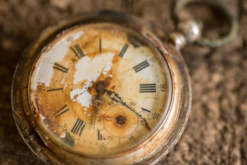 Antique silver broken pocket watch on wooden background.